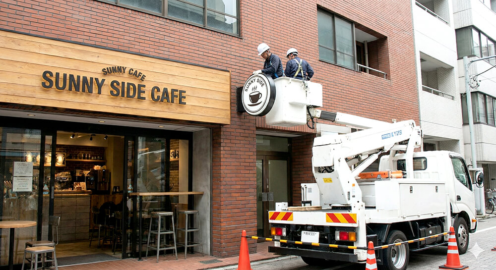 強風で看板が倒れないようにウエイトを設置している様子