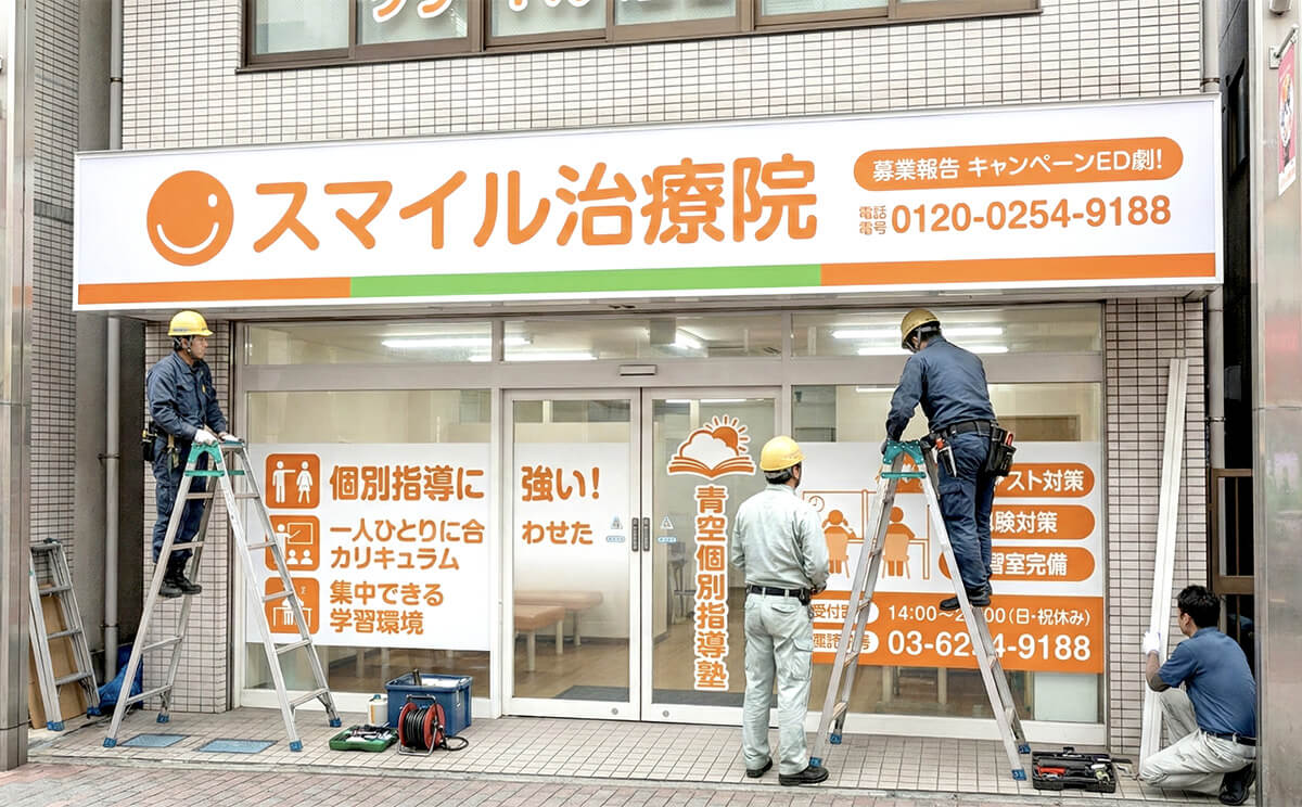 整体院看板の施工中のシーン・職人が取り付け作業中