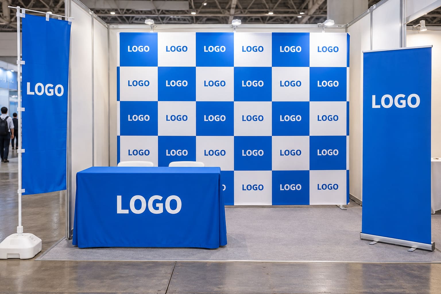 同じ青いデザインでそろえたバックパネル、テーブルクロス、ロールアップバナー、のぼりが並ぶ展示会のブース