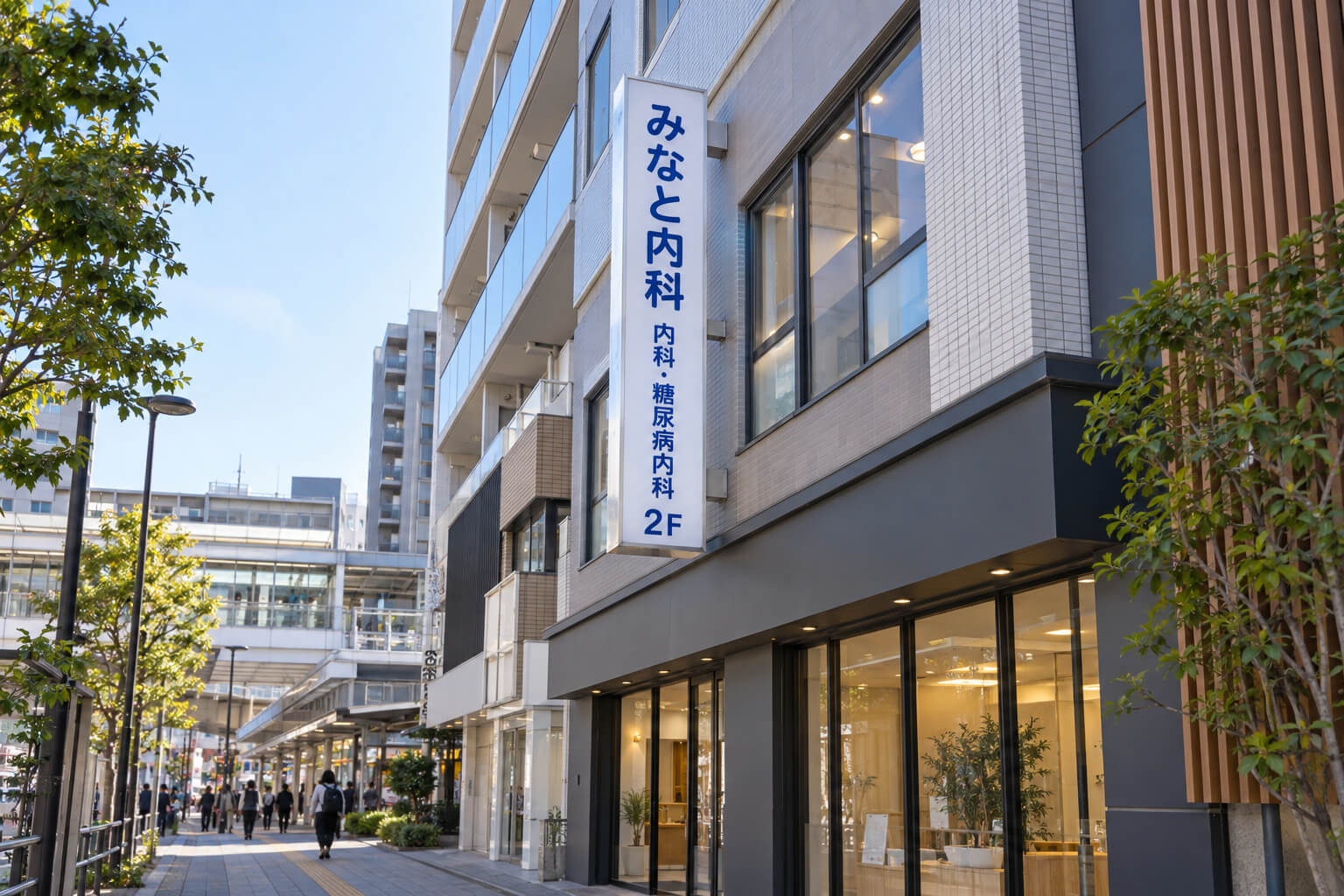 雑居ビルの2階に入る内科クリニックの袖看板。院名・診療科と「2F」の表示が通りから見える