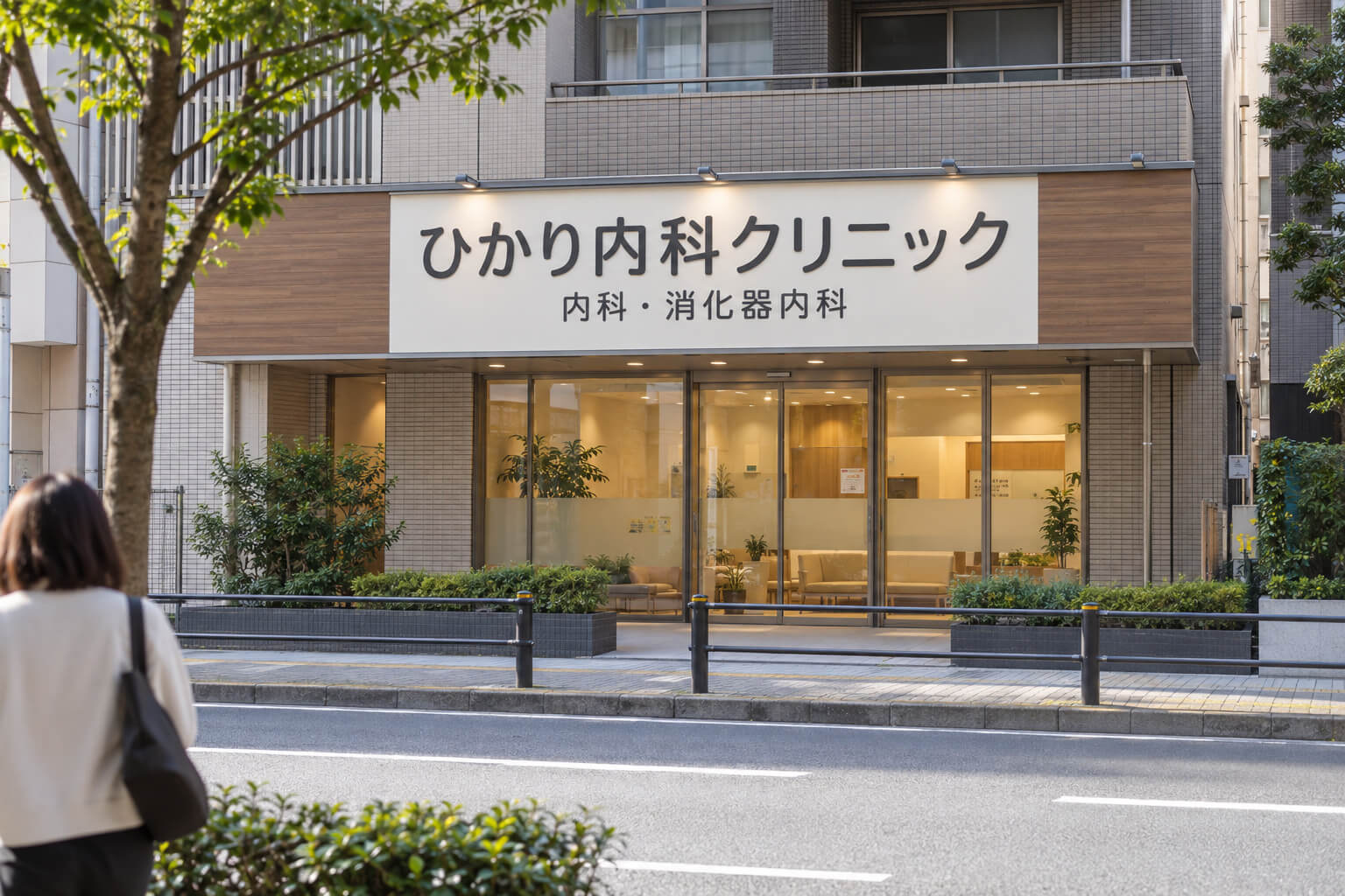 通りの向かい側の歩道から見た、内科クリニックの壁面看板。院名と診療科が大きく読みやすく表示されている