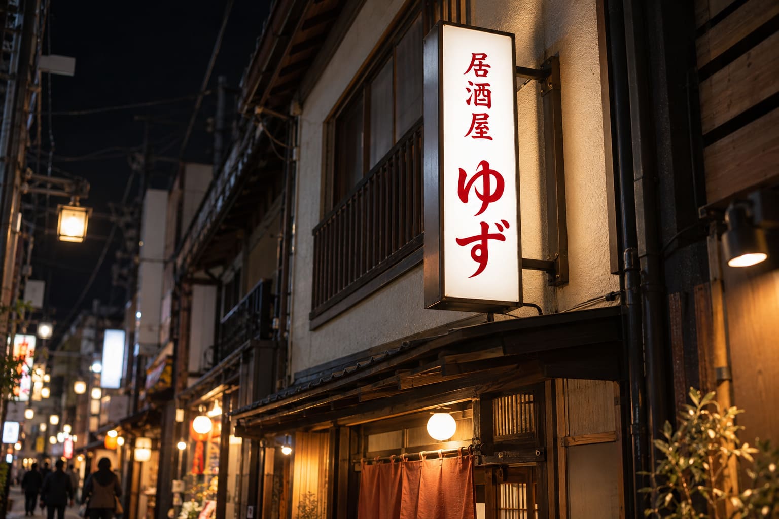 夜の商店街で、内照式の袖看板の文字と色が明るく光っている様子