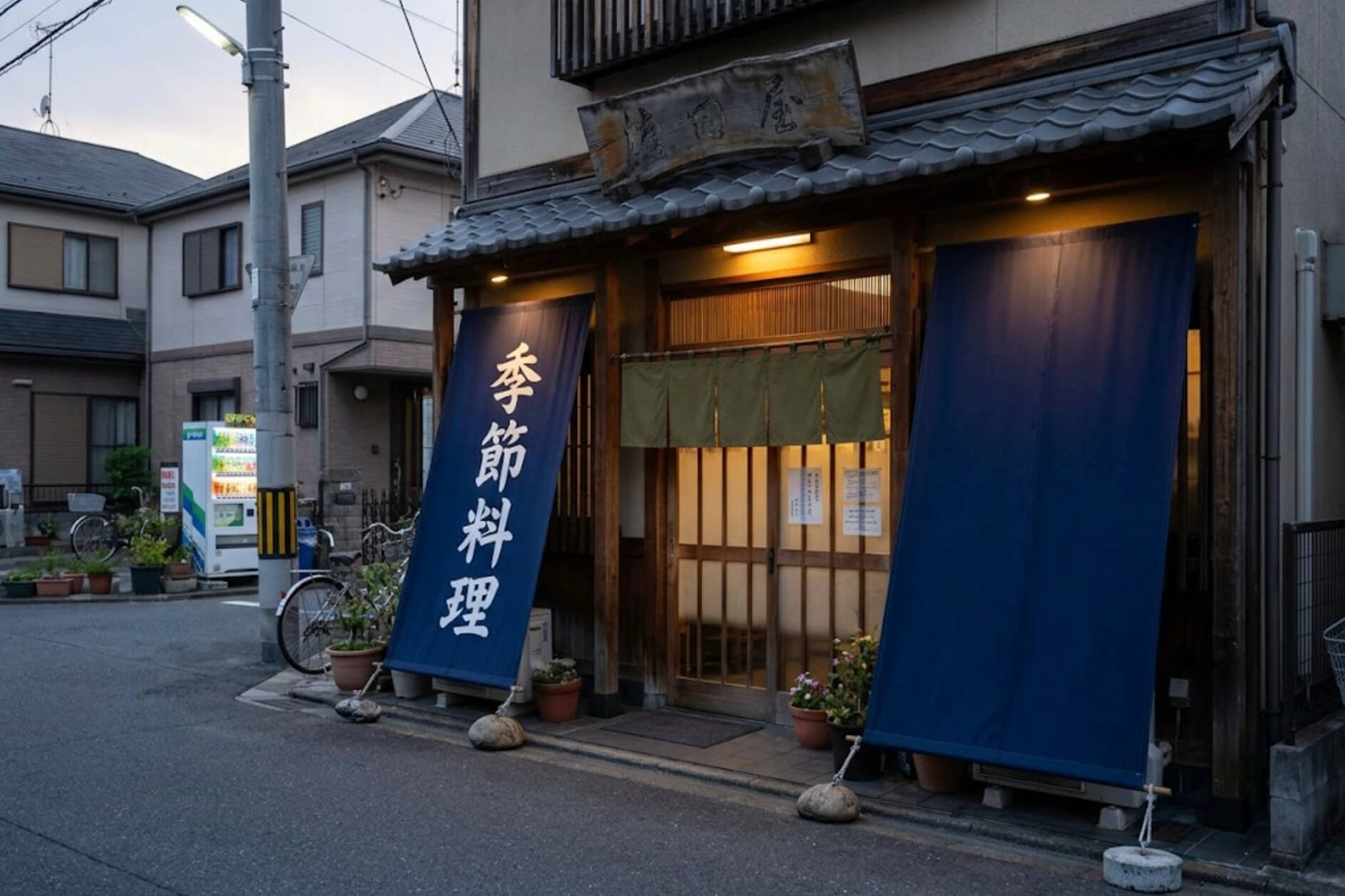 和食店の入口の両脇に、軒先から紺色の縦長の幕が下がっている様子