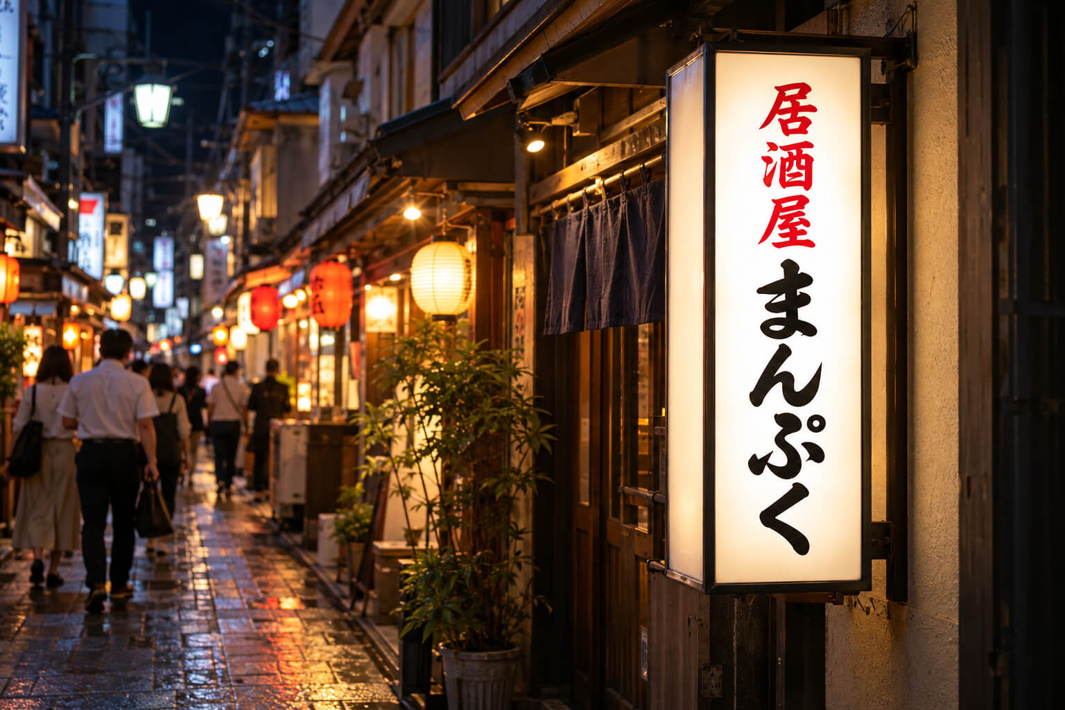 夜の商店街で、表示面を張り替えて鮮やかに光る内照式の袖看板