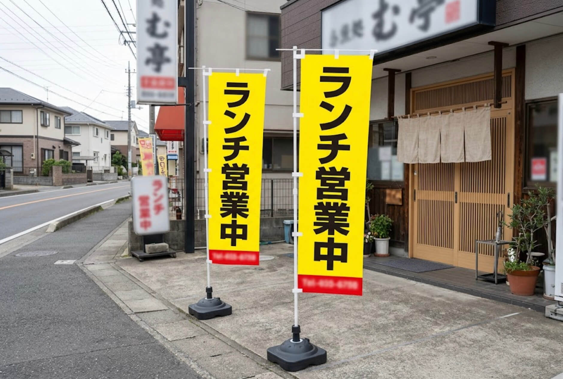 飲食店の店先に、大きな文字で短い言葉だけを書いたのぼり旗が並んで立っている様子