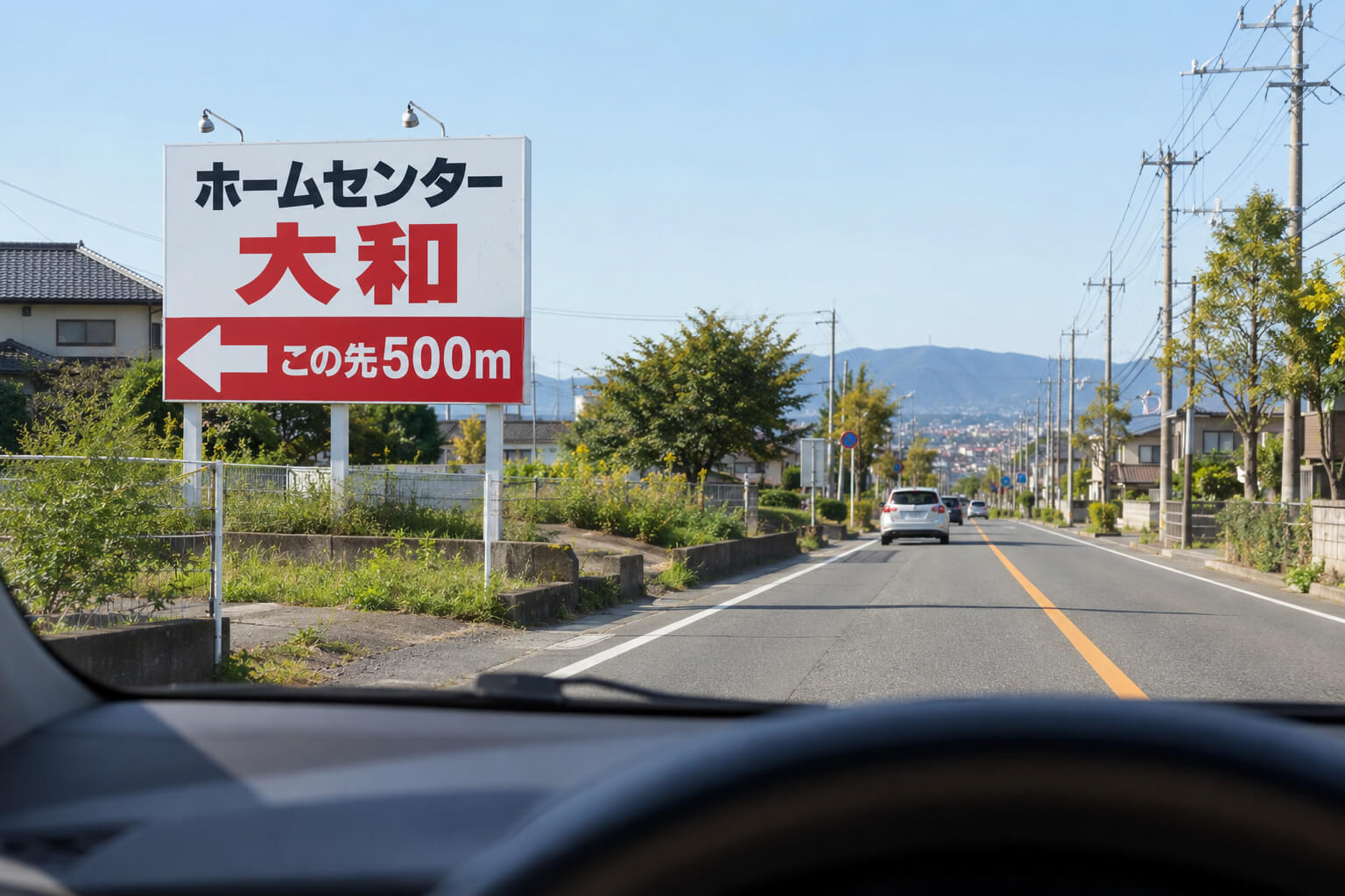 車の運転席から見た、道路沿いに立つ野立て看板。大きな店名と矢印、「この先500m」の文字がはっきり読める