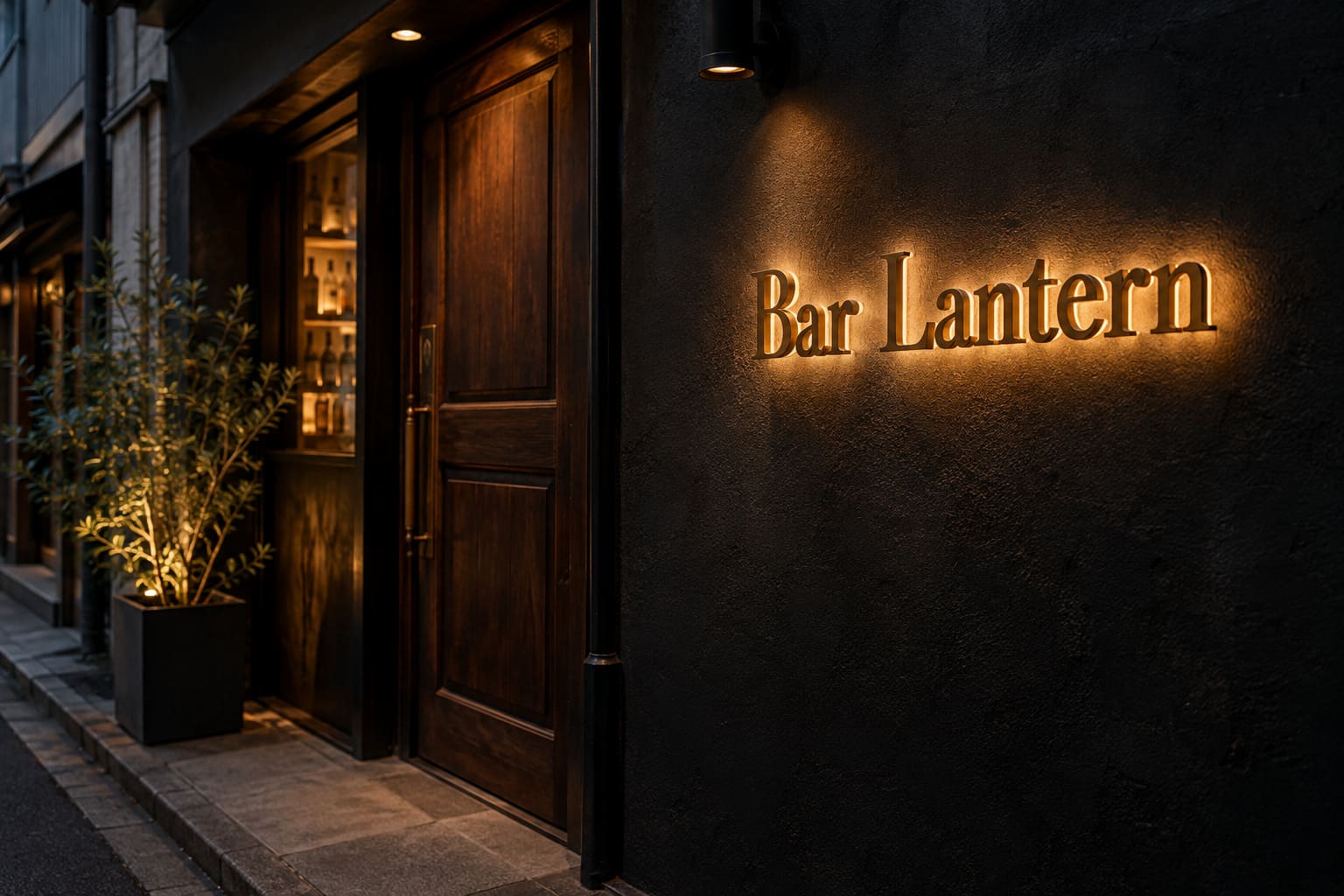 夜、黒い塗装の壁に真鍮色の立体文字で「Bar Lantern」と付き、文字の後ろの壁が暖かい色にぼんやり光っている様子